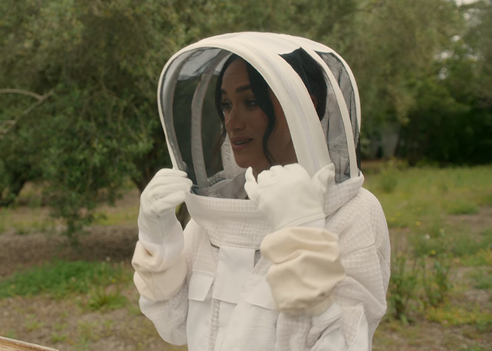 Meghan Markle con un traje de apicultura al aire libre, relacionado con los productos de la marca Meghan Markle de Williams Sonoma Discovery.