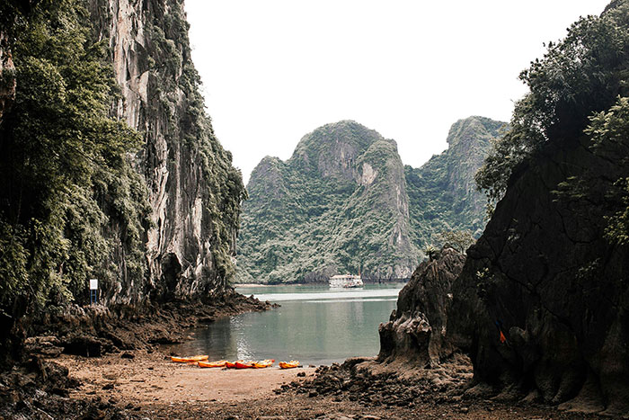 Vista escénica de cabina rodeada de acantilados y agua, destacando la naturaleza y la escapada de alquiler pacífico con niñeras cercanas.