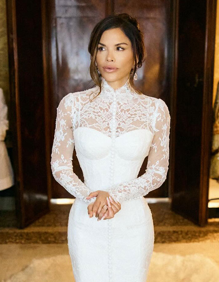 Mujer con un vestido de novia de encaje blanco que rompe la regla de boda de la boda en un elegante evento de celebración en el interior.