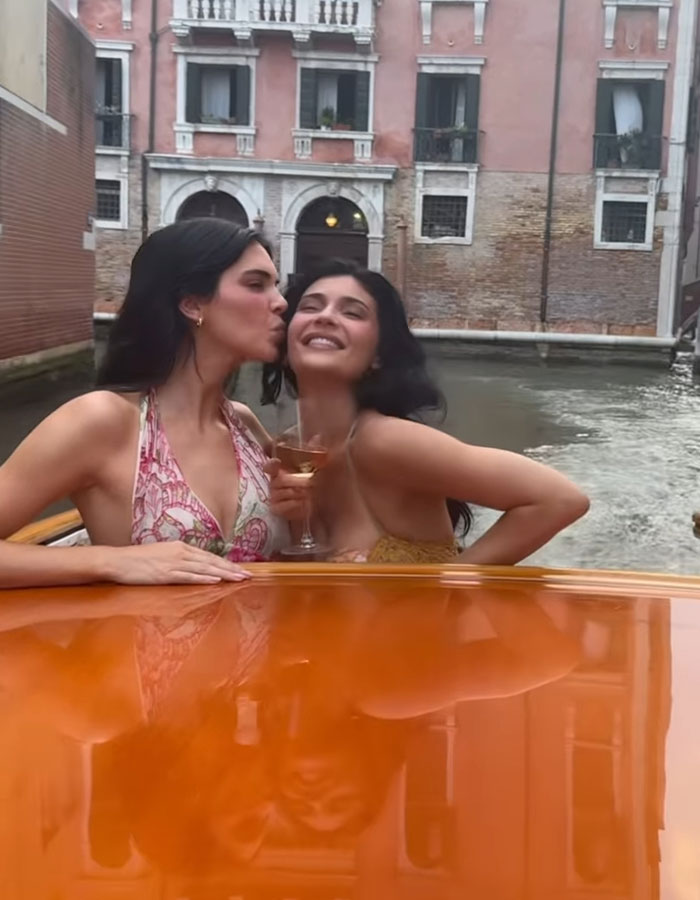 Kylie Jenner sonriendo con un amigo en un bote durante la celebración de la boda de Lauren Sánchez por el canal.