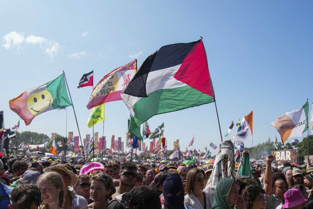 La bandera de Palestina se agita en una multitud de asistentes al festival en la actuación del trío Hip Hop Kneecap durante el Festival Glastonbury en Worthy Farm, Somerset, Inglaterra, el sábado 28 de junio de 2025.