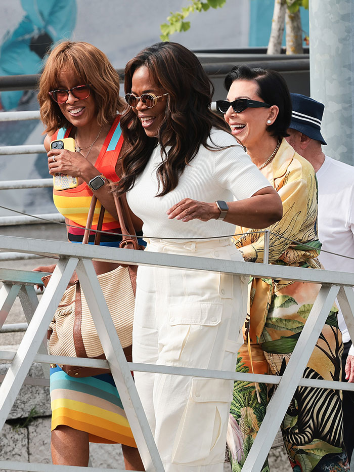 Tres mujeres sonriendo con gafas de sol, vestidas con estilo durante una excursión que muestra la celebridad de la festitud de la fiesta de fin de semana