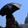 Una persona usa un paraguas mientras camina cerca de Capitol Hill en Washington, DC, el viernes. Estados Unidos está experimentando su primera ola de calor significativa del año, en las Grandes Llanuras y se está expandiendo a partes del Medio Oeste y los Grandes Lagos durante el fin de semana, según el Servicio Meteorológico Nacional.