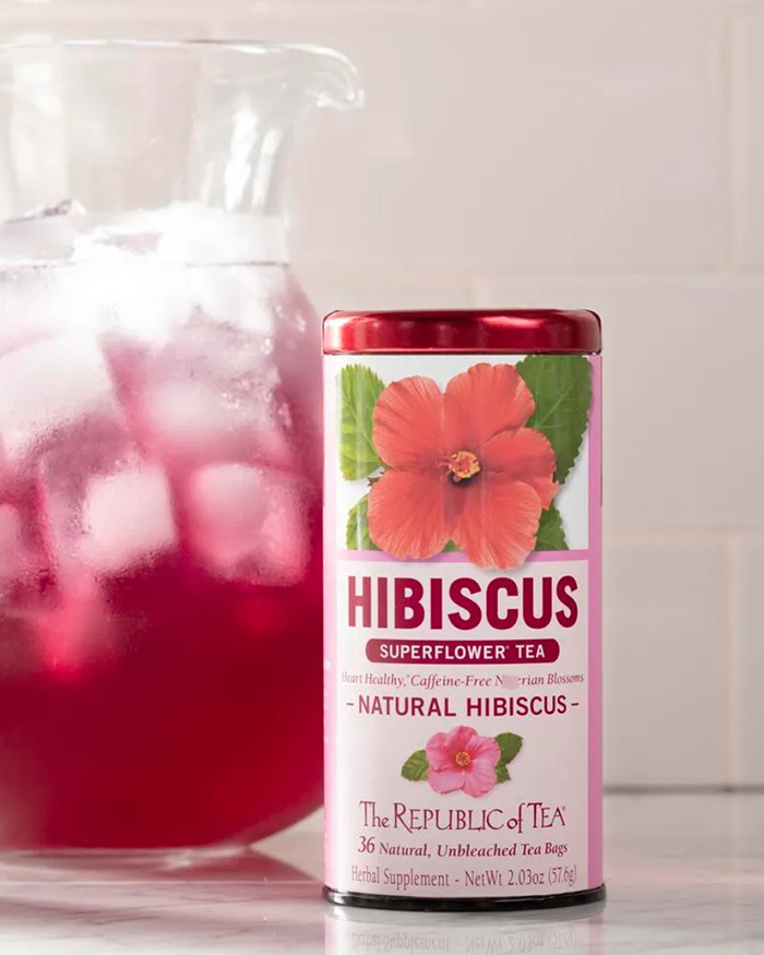 Producto de té de hibisco de la marca de Meghan Markle, ubicado junto a una jarra de té de hibisco helado en un mostrador de cocina.