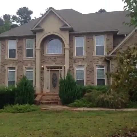 Foto de la casa Una foto de una casa de McMansion, con ladrillos y beige, pintura marrón, utilizada para hacer referencia al