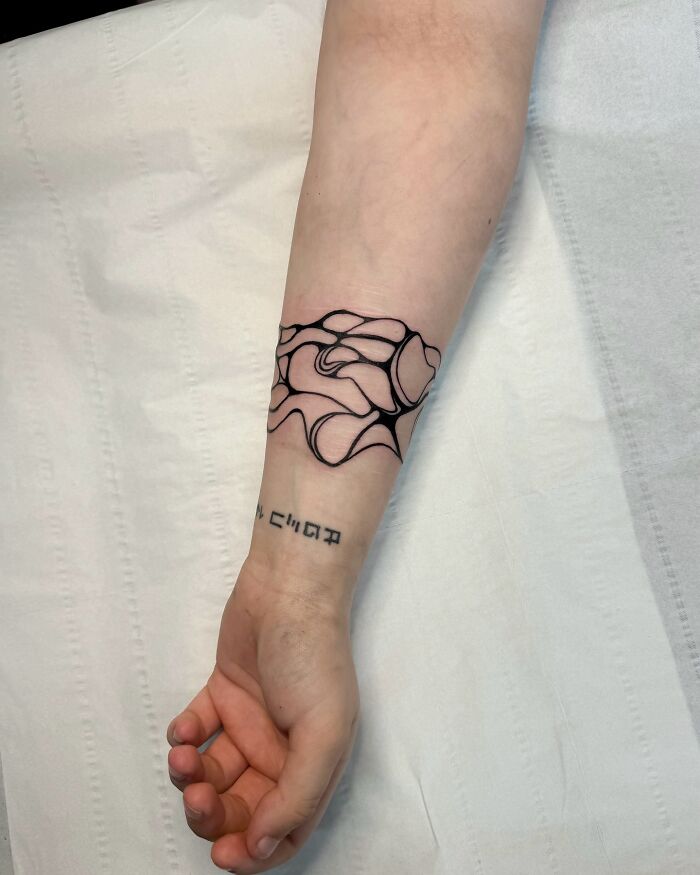 Cubra de tatuaje de tinta negra abstracta en el antebrazo, que muestra los encubrimientos creativos del artista del tatuaje que se vuelven virales.