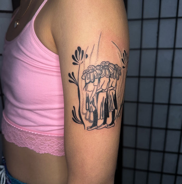 El encubrimiento del artista del tatuaje de figuras con cabeza floral en la parte superior del brazo en tinta negra con elementos decorativos de la planta.