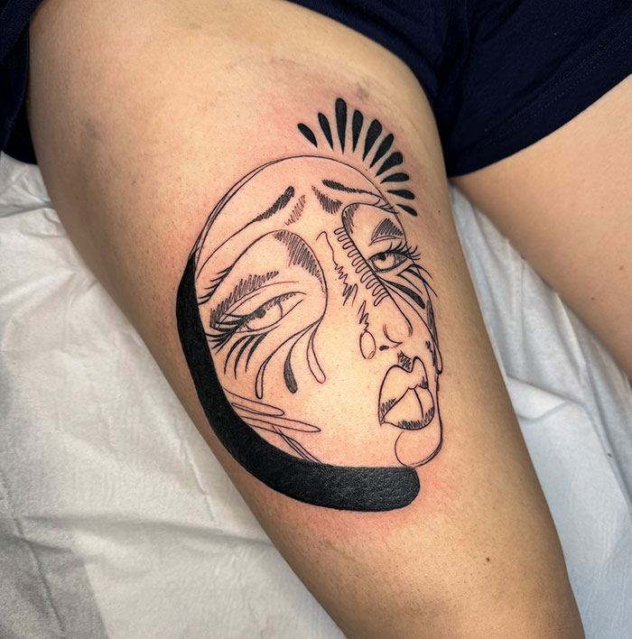 Abraz de tatuaje de cara abstracta en el muslo de tatuaje artista, mostrando diseño creativo y habilidad en encubrimientos.