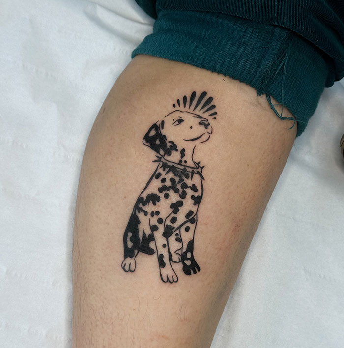 Tatuaje de perro dálmata con un mohawk en un muslo, mostrando el arte creativo de un tatuaje de un artista.