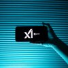 Una persona posee un teléfono que muestra el logotipo de la compañía de inteligencia artificial de Elon Musk, Xai y su chatbot, Grok.