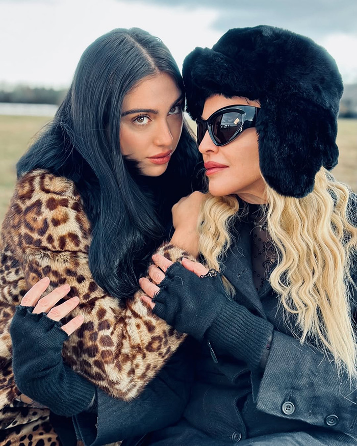 Dos mujeres vestidas con vestimenta de invierno comparten un momento íntimo que hace referencia a Gwyneth Paltrow y Madonna Friendship Fining.