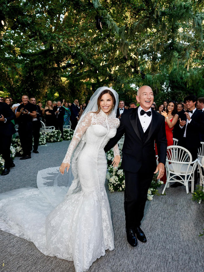 Jeff Bezos en un esmoquin con el pelo completo, caminando con la novia Lauren Sánchez en su ceremonia de boda al aire libre.