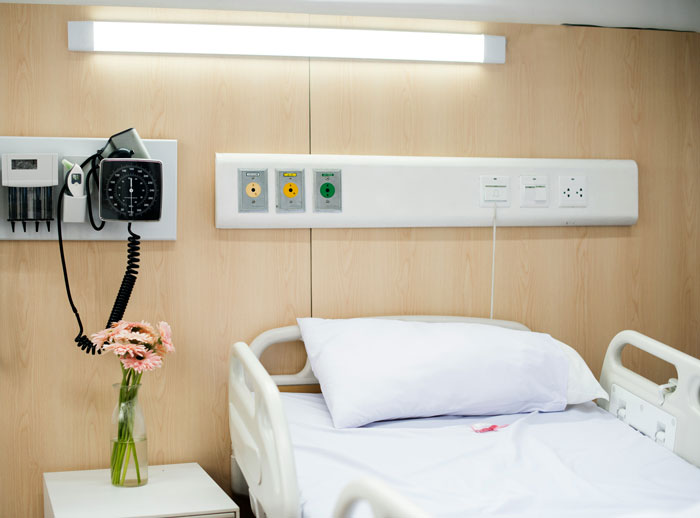 Habitación del hospital con cama y flores vacías, simbolizando la respuesta del grupo de apoyo después de que la mujer terminó su propia vida hambrienta de hambre.