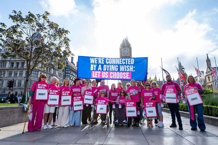 El grupo de apoyo con camisas rosadas contiene letreros y banner que defiende la elección después de que la mujer terminó la vida al morir de hambre.
