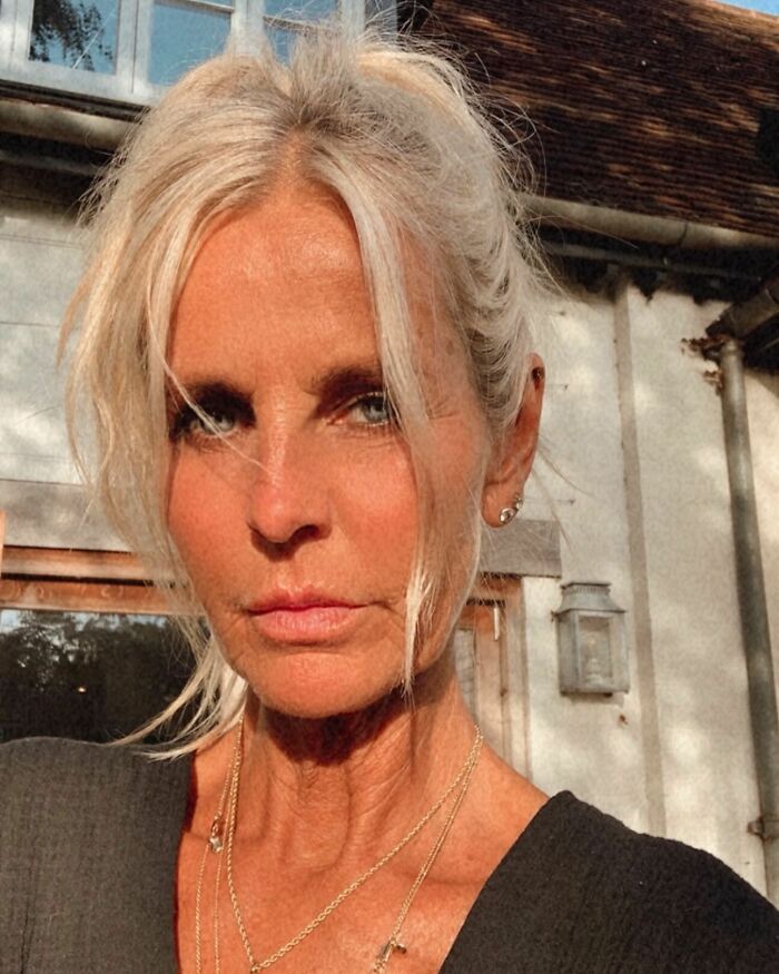 Ulrika Jonsson al aire libre con una cara bronceada, cabello claro retrocedido, con delicados collares de oro y una parte superior oscura.