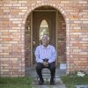 Robert Taylor se sienta fuera de la casa de dos pisos que construyó en la reserva, Louisiana. Construyó su casa de ladrillos de dos pisos casi al mismo tiempo que la planta de DuPont comenzó a funcionar, ahora llamada Denka Performance Elastomer, se encuentra a poca distancia de Taylor's House en St. John Parish.