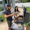 Stoio Kachev y Doanh Nghiem Cocina la cena al aire libre en una parrilla eléctrica grande.