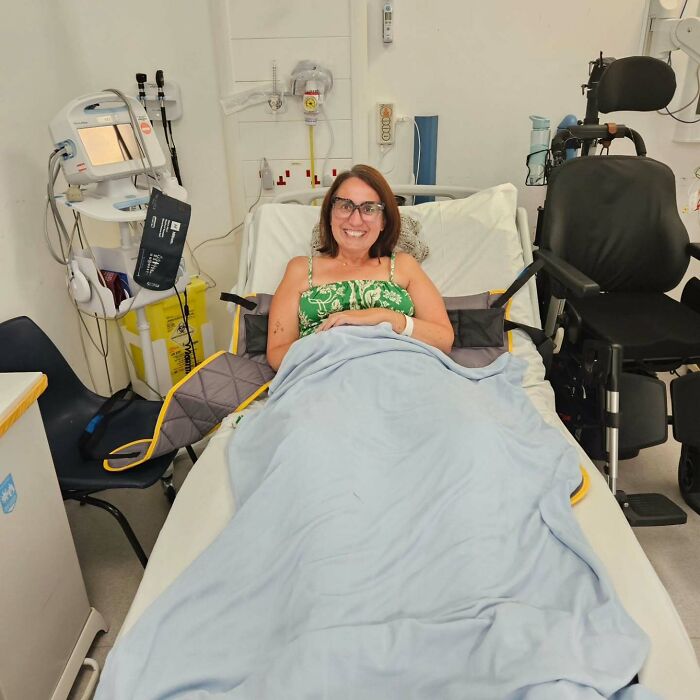 Mujer sonriendo en la cama del hospital con equipo médico cercano después de que la mujer terminó su propia vida al hambre del grupo de apoyo.