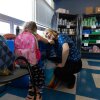 Megan Mainzer, el enlace de McKinney-Vento para las Escuelas Públicas de Middletown en Rhode Island, habla con una niña en una despensa de comida y ropa escolar que se administra, en parte, con dinero federal de subvenciones.