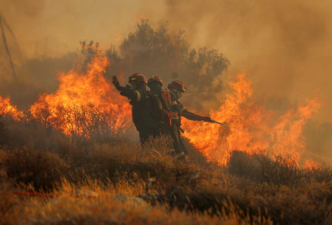 El bombero usa una manguera mientras el intento de extinguir el incendio cerca de la ciudad de IERAPETRA en la costa sur de la isla de Creta, Grecia, el jueves, cuando un incendio forestal que se movía rápidamente llevó a las autoridades a limpiar aldeas y áreas costeras, dijeron las autoridades.