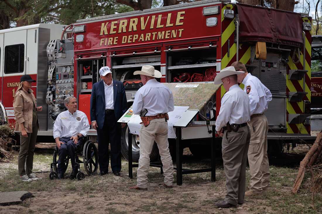 La presidenta Trump, la primera dama Melania Trump y el gobernador de Texas, Greg Abbott, se reúnen con el personal de servicios de emergencia locales mientras encuestan daños por inundaciones a lo largo del río Guadalupe el 11 de julio, en Kerrville, Texas.