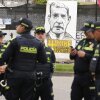 La policía se para frente a una pancarta que lee en español 