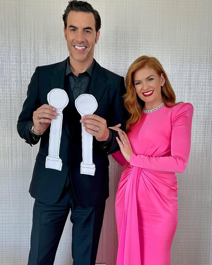 Dos personas que se hacen pasar juntas, con uno de los recortes de papel, relacionados con las críticas columnistas del cuerpo Marvel de Sacha Baron Cohen.