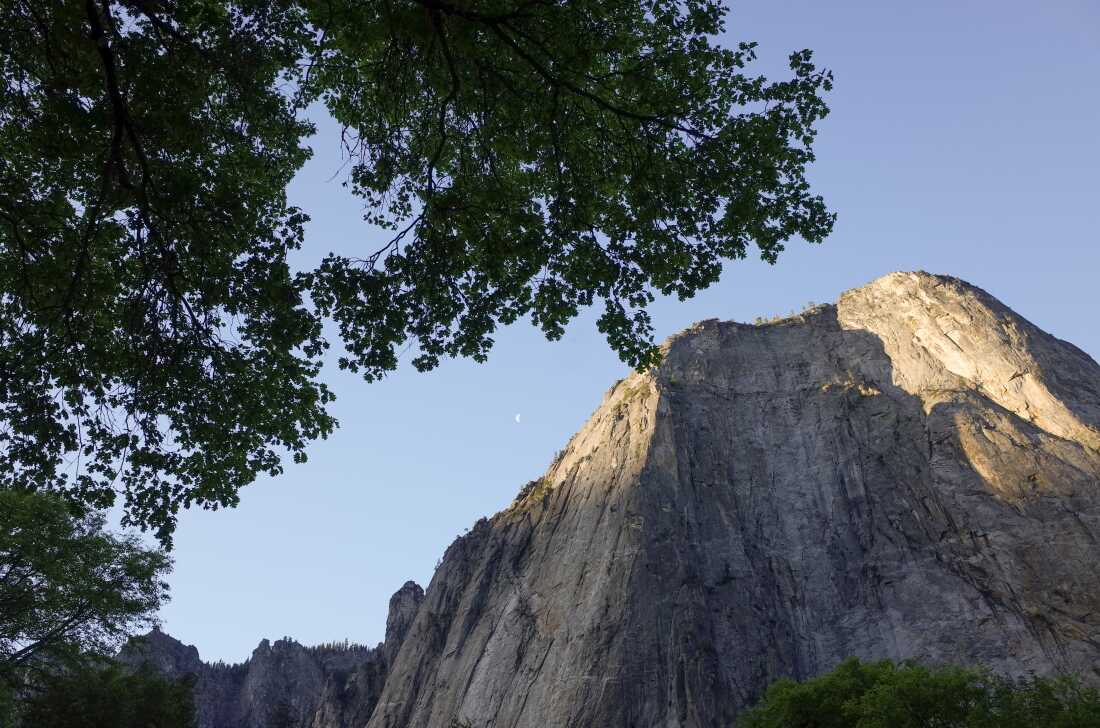 El sol se eleva sobre uno de los altos monolitos de granito que surgen del valle de Yosemite.