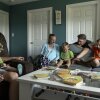 Megan y Stephen Alger, así como cuatro de sus hijos, están situadas alrededor de una mesa de café en su hogar. Megan Alger y dos de sus hijos están sentados en un sofá. Un hijo mayor y un hijo de la era pequeña están sentados en un sillón, y Stephen Alger está detrás del sofá. Los tres niños más jóvenes tienen libros en sus vueltas, y los libros para niños están dispersos en la mesa de café.