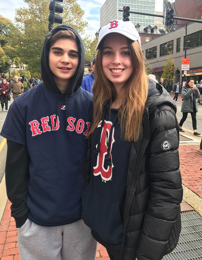 Dos jóvenes con ropa de los Medias Rojas al aire libre, vinculados al impactante giro en el violento incidente de Disney World que involucra a la familia.