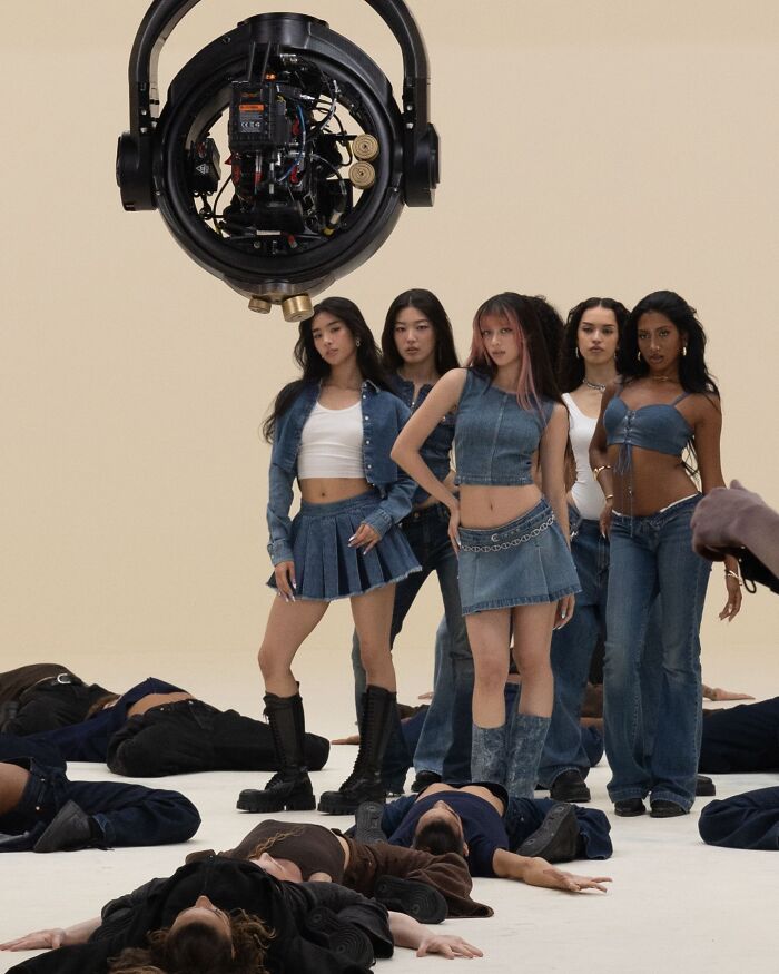 Modelos que usan jeans Gap posando en una sesión de fotos de estudio con otros tirados en el piso, mostrando campaña de moda de mezclilla.