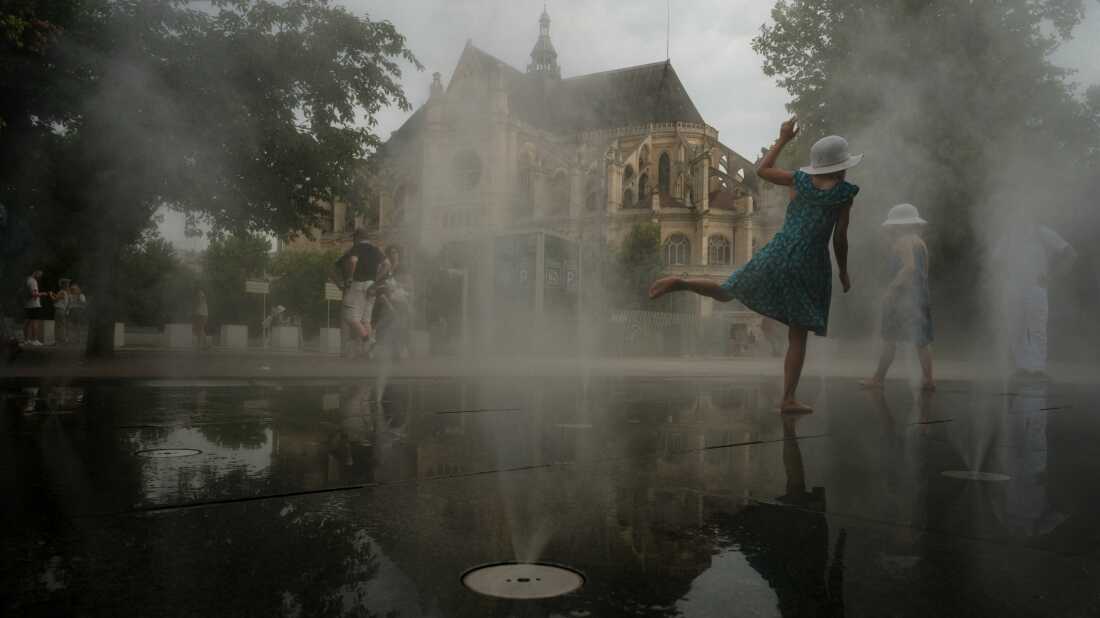 Los niños se enfrían en una fuente de niebla en el centro de París en medio de una ola de calor, el 13 de agosto.