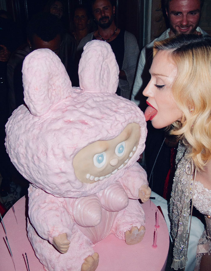 Madonna celebrando con un pastel rosa único, abrazando el consejo de cambio cosmético de su joven novio.