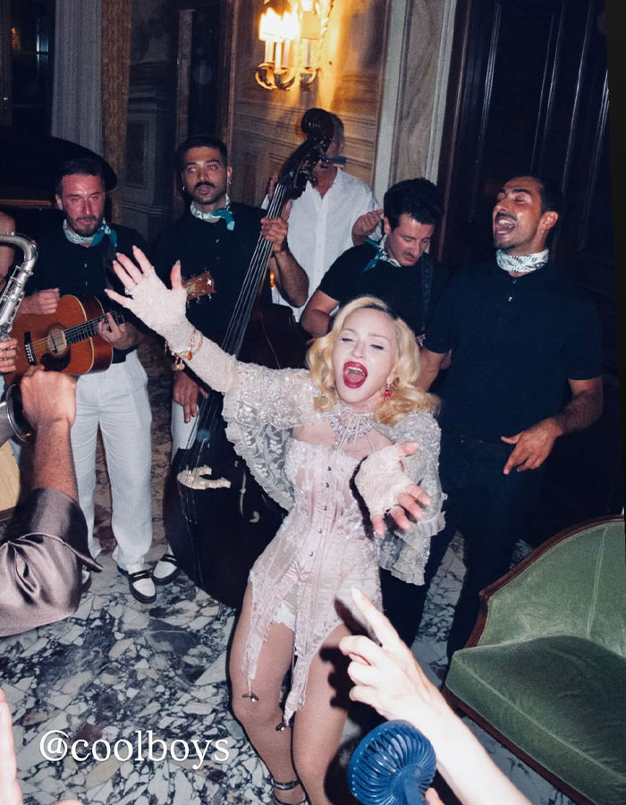 Madonna actuando felizmente con una banda en vivo, abrazando el cambio mientras sigue los consejos cosméticos de su novio.
