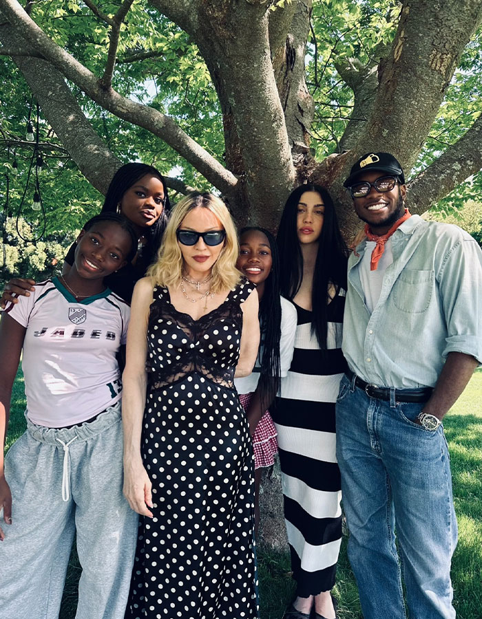 Madonna al aire libre con amigos debajo de un árbol, mostrando su estilo en medio de consejos de cambio cosmético de su novio de 29 años.