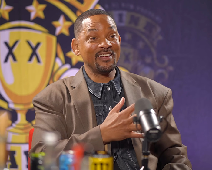 Will Smith habló en un micrófono durante una entrevista, con un enfoque en la IA y fingir la controversia de las multitudes.