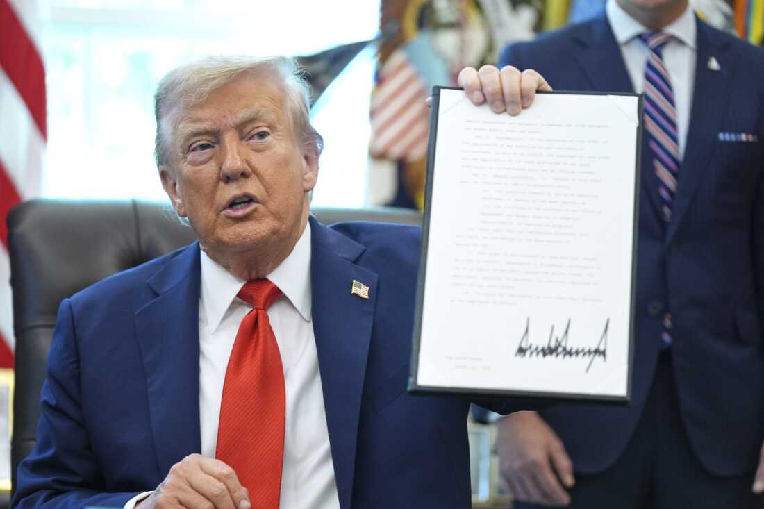 El presidente Trump tiene una orden ejecutiva firmada que requiere que el Departamento de Justicia investigue los casos de quema de banderas, en la Oficina Oval de la Casa Blanca el lunes.