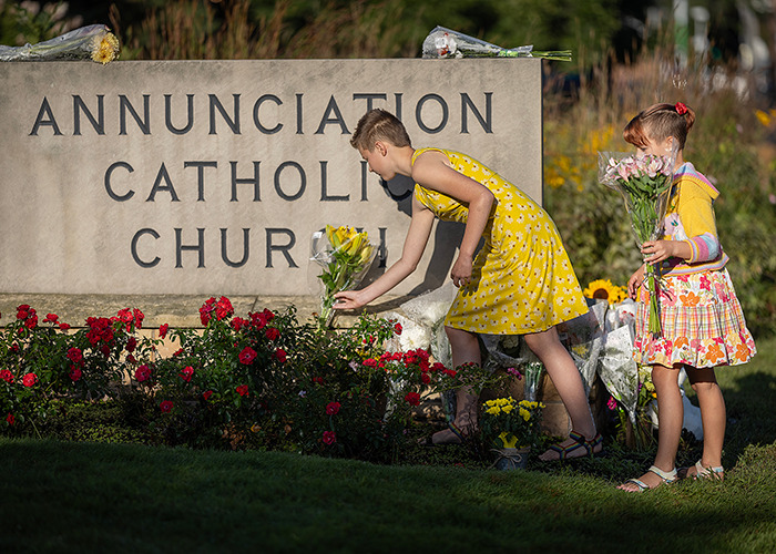 Dos chicas que colocan flores en la Iglesia Católica Annunciation, relacionadas con la novia peluda del sospechoso de Minneapolis y las entradas de revistas.