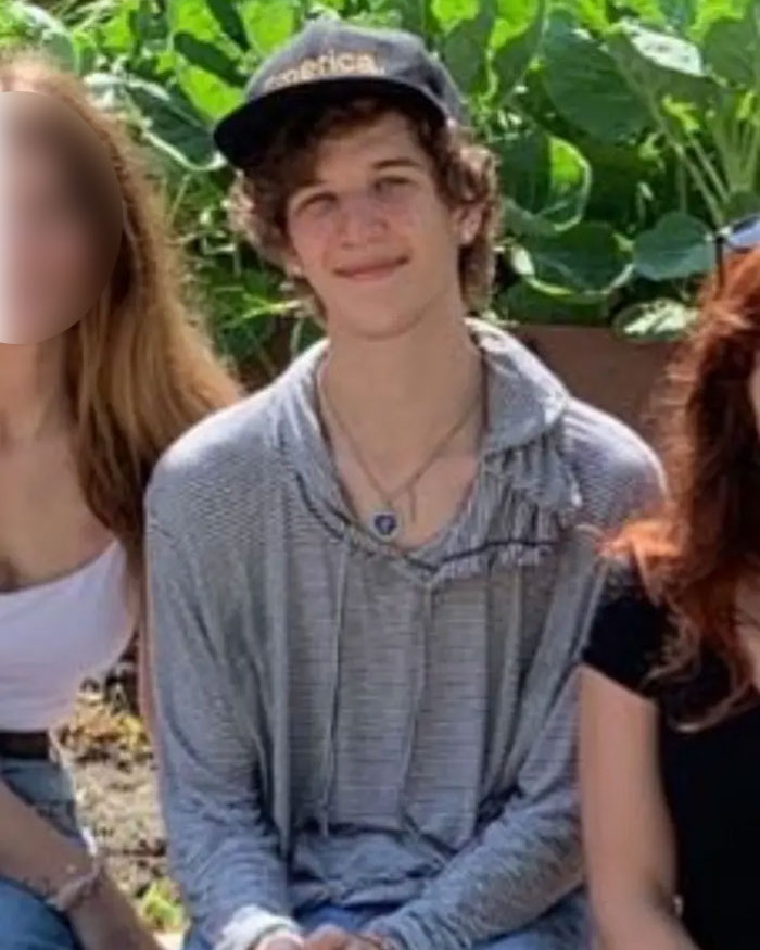 Young Man con una gorra y una sudadera con capucha gris sentada al aire libre con plantas verdes frondosas en el fondo, la novia peluda del sospechoso de Minneapolis