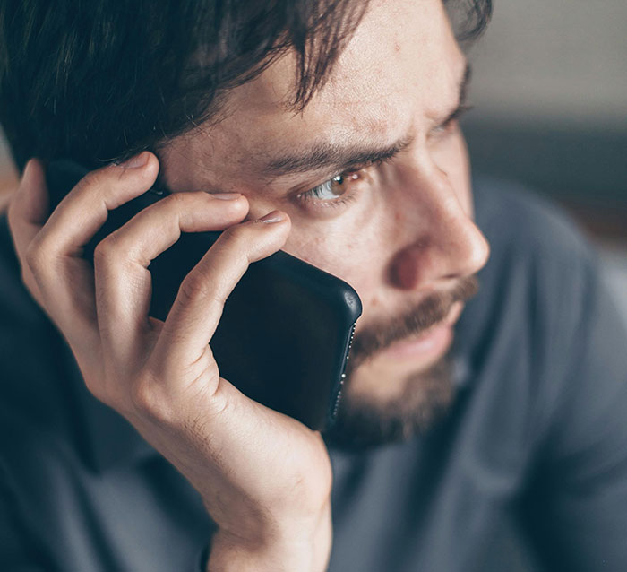 El joven se ve preocupado mientras habla por teléfono, que representa la situación de ruptura de novio titulada Lady Manipuling.
