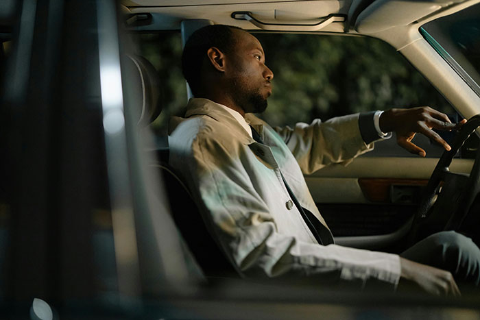 Hombre sentado dentro del auto que se ve serio, ilustrando titulada Lady Manipulating Boyfriend y exige paseos gratuitos.