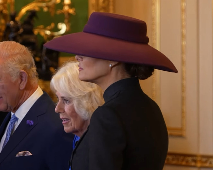 Melania Trump con un gran sombrero morado y un atuendo negro, mostrando opciones de vestuario durante el evento de visita de estado del Reino Unido.