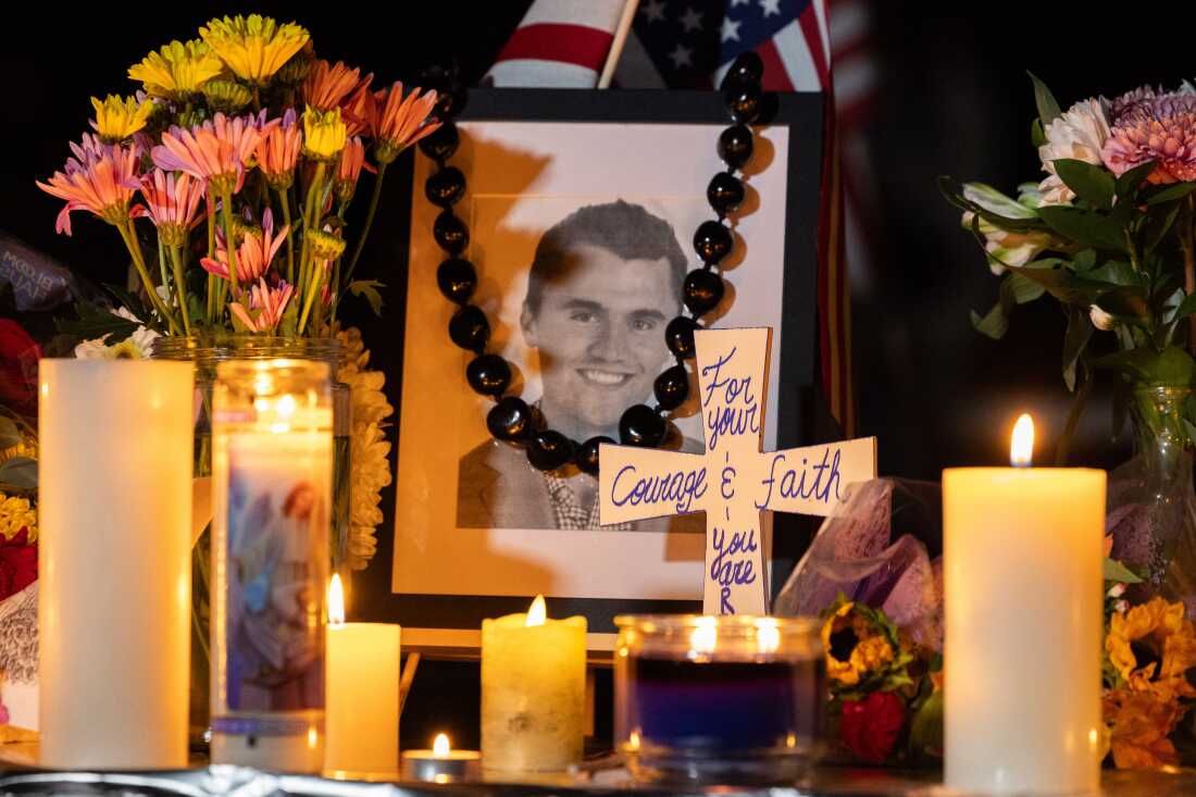 Las velas y las flores se ven cerca de un retrato de Kirk en un memorial improvisado durante una vigilia a la luz de las velas en Memorial Park en Provo, Utah, el 12 de septiembre