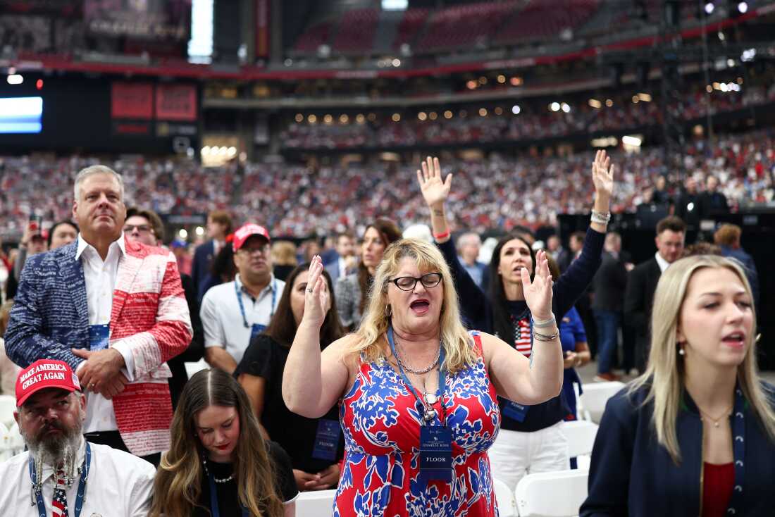 La gente reza por delante del Servicio Memorial Público para el activista de derecha Charlie Kirk en el Estadio State Farm en Glendale, Arizona, el 21 de septiembre de 2025. 