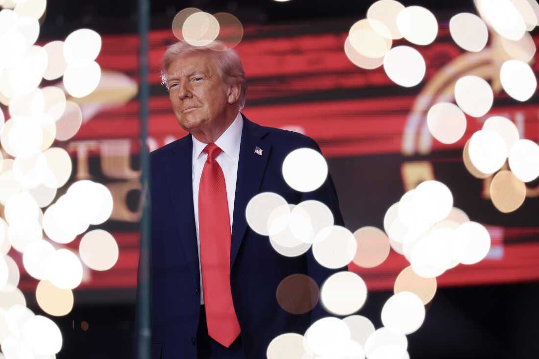 El presidente Donald Trump camina en el escenario durante el servicio conmemorativo para el activista político Charlie Kirk.