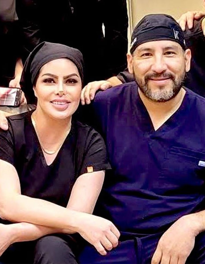 Dos profesionales médicos con matorrales y revestimientos de la cabeza, sonriendo mientras posan para una foto grupal.