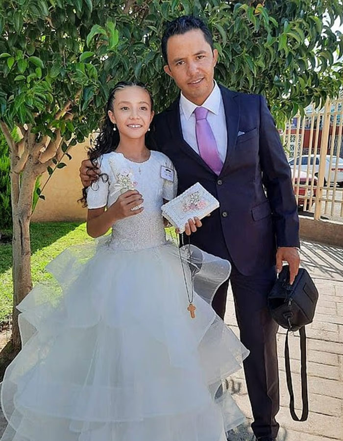 Niña con vestido blanco de pie con un hombre con traje al aire libre en relación con el caso de agrandamiento de los senos del cirujano.