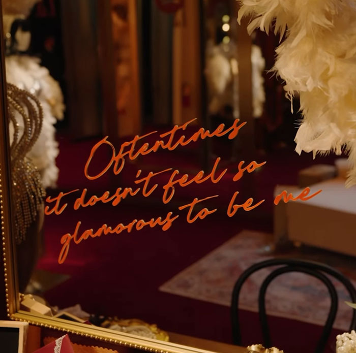 Letras escritas a mano que reflejan la reacción sorda del tono sobre la canción de Taylor Swift filtrada en un lujoso vestuario.