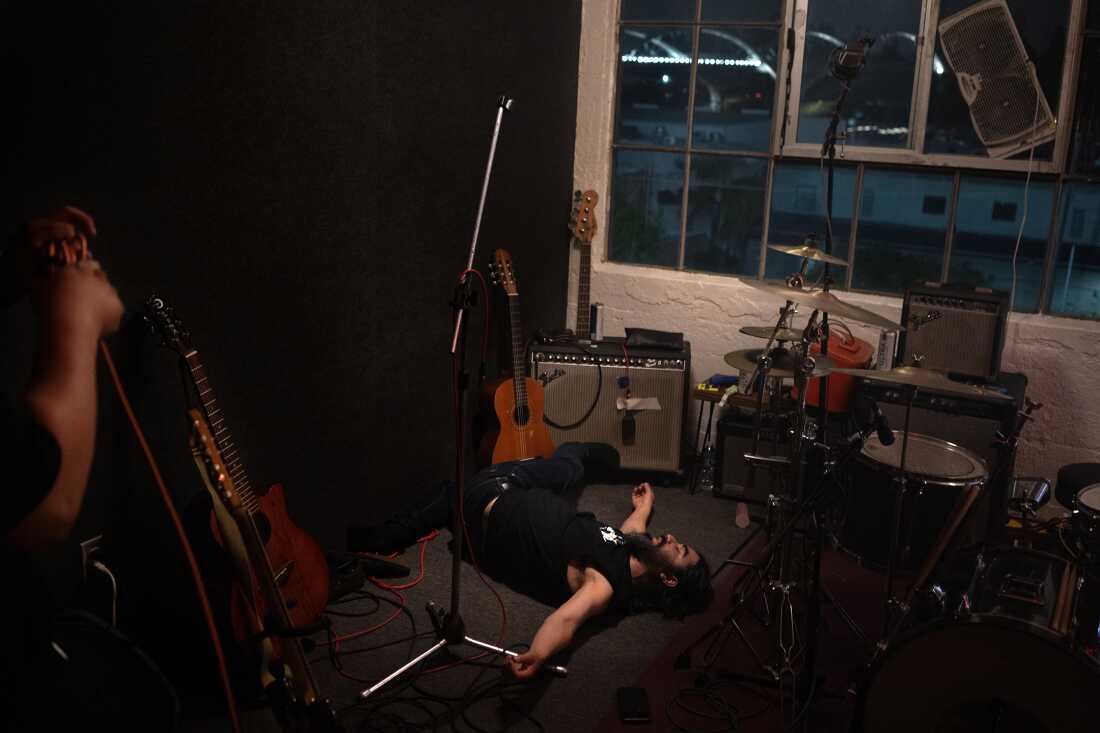 UNITED STATES, LA - Adolfo Mercado, the drummer of the band, lays on the floor at the end of practice session in Los Angeles on May 18, 2023. The band Spaghetti Cumbia created their own sub-genre by combining cumbia with western styles and rock ’n roll. They grew up on the east side of Los Angeles when gang violence plagued the area; the members turned to music as an alternative path. Now, they rock clubs, while keeping day jobs to support their families.