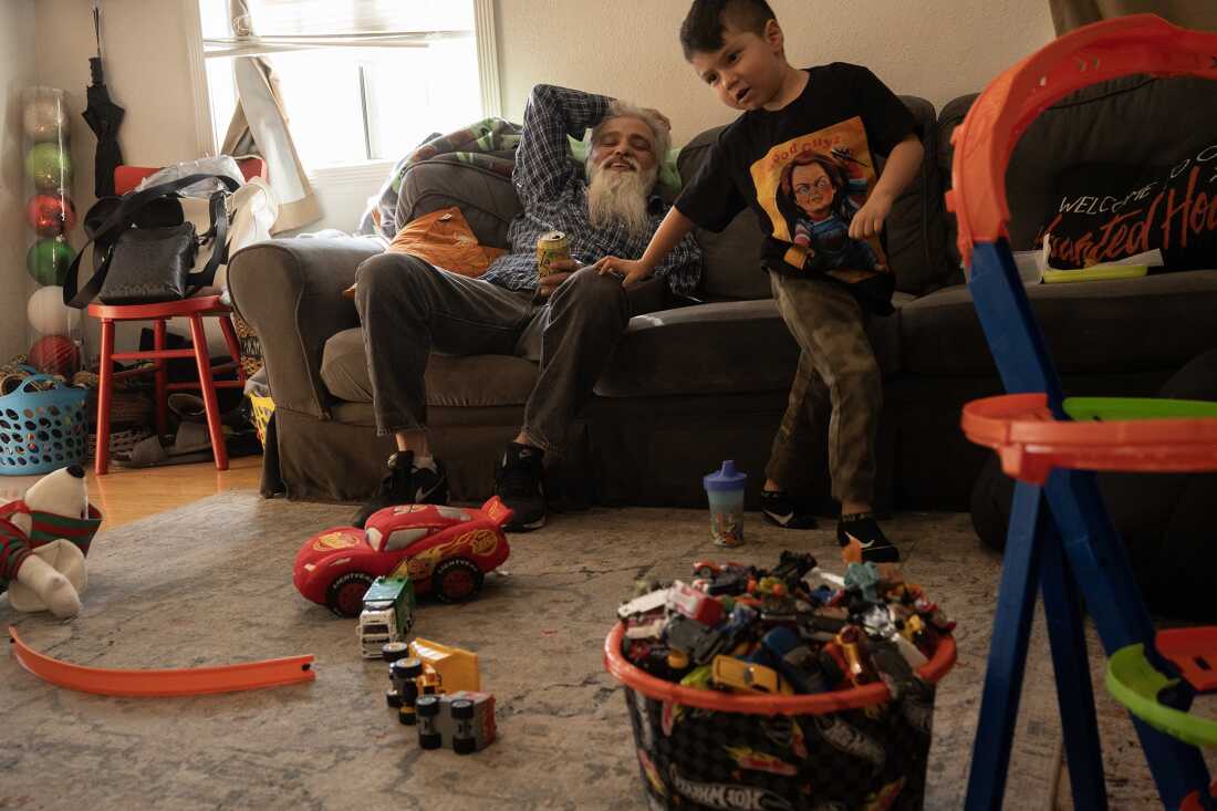 UNITED STATES, LA - Marcel Campos, lead singer of Spaghetti Cumbia, hangs out with his son, Ethan Luke, before heading off to a gig at his home in Alhambra, Los Angeles on November 3, 2023. The band Spaghetti Cumbia created their own sub-genre by combining cumbia with western styles and rock ’n roll. They grew up on the east side of Los Angeles when gang violence plagued the area; the members turned to music as an alternative path. Now, they rock clubs, while keeping day jobs to support their families.
